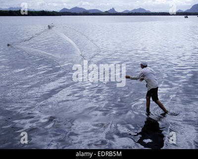 Man throwing et tirant en filet de pêche en rivière, Vitoria, Espirito Santo, au Brésil. Banque D'Images