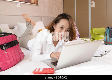 Young woman using laptop avec sacs à main autour de Banque D'Images