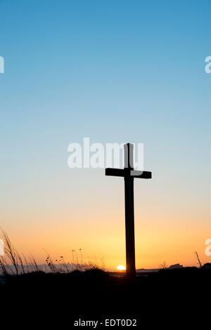 St Cuthbert's Isle croix de bois sur l'Île Sainte de Lindisfarne, au lever du soleil. Northumberland, Angleterre. Silhouette Banque D'Images