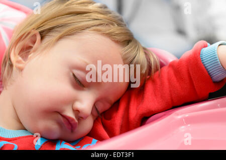 Mignon bébé garçon endormi sur une chaise haute Banque D'Images