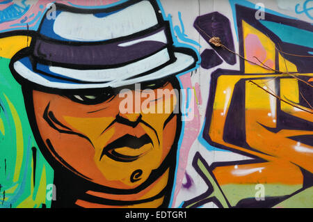 Homme avec fedora hat abstract colorful graffiti sur mur de la ville. Urban street art. Banque D'Images