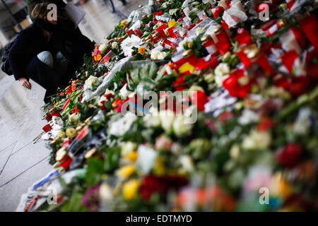 (150110) -- BERLIN, 10 janvier 2015 (Xinhua) -- une femme fixe fllowers devant l'Ambassade de France à Berlin pour commémorer les victimes de l'attentat sur le Français hebdomadaire satirique 'Charlie Hebdo', à Berlin, Allemagne, le 9 janvier 2015. Douze personnes ont été tuées mercredi dans une fusillade à Paris le bureau de l'hebdomadaire Charlie Hebdo. (Xinhua/Zhang Fan) Banque D'Images