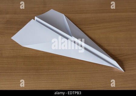 Avion en papier en forme de flèche claccic sur une table en bois Banque D'Images