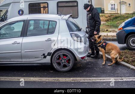 Dammartin-en-Goele, France. 9 janvier, 2015. Un chien policier manipulé par un policier vérifie une voiture à Dammartin-en-Goele, au nord-est de Paris, où deux frères soupçonnés d'attaque Charlie Hebdo a tenu une personne en otage comme les hommes armés à coins de la police, le 9 janvier, 2015. La force de sécurité français lancé assaut contre Kouachi frères, tués les deux suspects de l'attaque de Charlie Hebdo. Source : Xinhua/Alamy Live News Banque D'Images