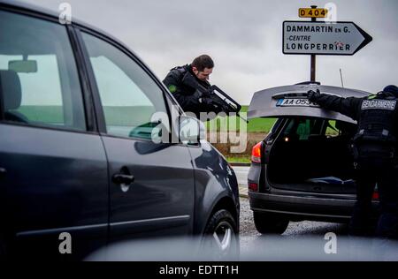 Dammartin-en-Goele, France. 9 janvier, 2015. Un policier vérifie une voiture à Dammartin-en-Goele, au nord-est de Paris, où deux frères soupçonnés d'attaque Charlie Hebdo a tenu une personne en otage comme les hommes armés à coins de la police, le 9 janvier, 2015. La force de sécurité français lancé assaut contre Kouachi frères, tués les deux suspects de l'attaque de Charlie Hebdo. Source : Xinhua/Alamy Live News Banque D'Images