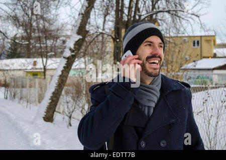 Bearded man talking on a cell phone en hiver Banque D'Images