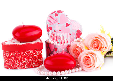 Coeur rouge bougies, roses, collier et coffrets cadeaux sur fond blanc. Banque D'Images