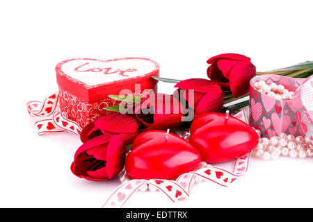 Coeur rouge des bougies, des tulipes, des colliers et des coffrets cadeaux sur fond blanc. Banque D'Images