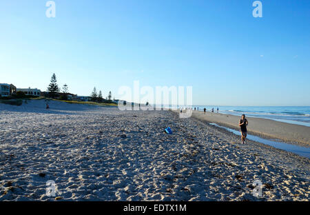 Tôt le matin, les coureurs et les personnes exerçant sur la magnifique plage de sable grand ouvert avec l'océan calme. Prise à 7h00 dans le sud de l'Australie Banque D'Images