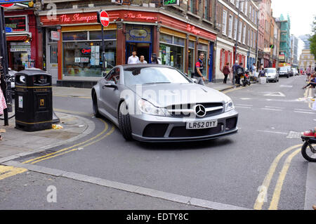 Voiture de sport Mercedes argent prenant un coin sur Brick Lane, Shoreditch, Londres, Angleterre Banque D'Images