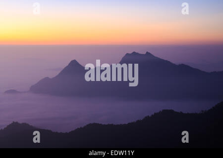 Mer de brouillard et les montagnes (silhouette) avec le lever du soleil le matin à Phu Chi Fa, Chiangrai, ,Thaïlande Banque D'Images