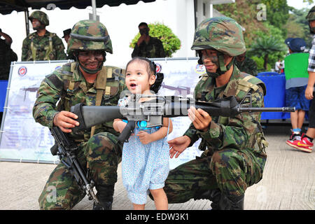 Bangkok, Thaïlande. 10 janvier, 2015. Un enfant touche une mitrailleuse sur la Journée de l'enfance à l'Académie de la Marine royale thaïlandaise dans le sud de Bangkok, Thaïlande, 10 janvier 2015. La Journée nationale de l'enfant est célébrée le deuxième samedi de chaque mois de janvier. Credit : Rachen Sageamsak/Xinhua/Alamy Live News Banque D'Images