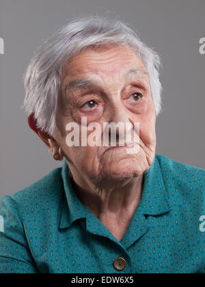 Portrait d'une femme âgée dans un studio shot et isolé sur fond gris Banque D'Images