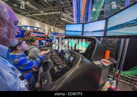 Londres, Royaume-Uni. 9 janvier, 2015. Deux garçons ont un rendez-vous sur un simulateur de navigation Raymarine sophistiqué qui a été connecté à un vrai moteur console à partir d'un Sunseeker Predator. Le MCG FX London Boat Show, qui aura lieu du 09-18 janvier 2015 à l'ExCel Centre, Docklands, Londres. 09 Jan 2015. Crédit : Guy Bell/Alamy Live News Banque D'Images