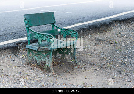 Banc solitaire près de la rue en parc urbain. Banque D'Images
