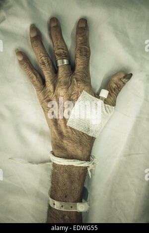 Main de l'ancien patient avec bouchon sur le lit dans un hôpital (style vignette) Banque D'Images