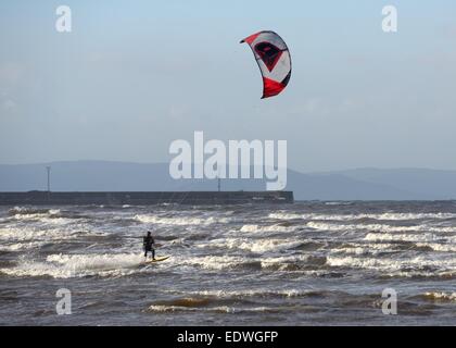 Plage de Troon, Ayrshire, Ecosse. 10 janvier, 2015. Météo britannique. Un kite surfer permet de tirer le maximum des vents forts et une mer qui n'ont cessé d'être battues en Écosse. Banque D'Images