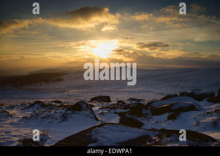 Royaume-Uni, South Yorkshire, Peak District, Upper Burbage Valley, coucher de soleil sur Carl Wark et Owler Tor pendant l'hiver. Banque D'Images