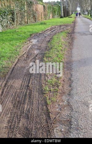 Destruction d'un point d'herbe sur une petite route rurale par des camions lourds. 10 Janvier 2015 Banque D'Images