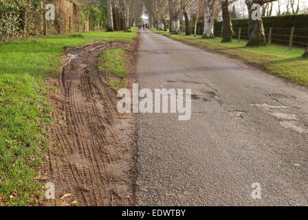 Destruction d'un point d'herbe sur une petite route rurale par des camions lourds. 10 Janvier 2015 Banque D'Images