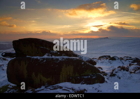 Royaume-Uni, South Yorkshire, Peak District, Upper Burbage Valley, coucher de soleil sur Carl Wark et Owler Tor pendant l'hiver. Banque D'Images