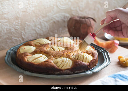 Accueil gâteau aux pommes sur un plat en métal brossé, avec du miel Banque D'Images