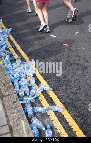 Bouteilles d'eau sur le terrain et les participants s'exécutant dans le Marathon de Londres Banque D'Images