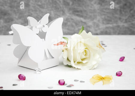 Faveur de mariage boîtes en forme de papillon sur une nappe blanche avec des arcs,Silver Heart confetti et petites décorations de table diamant Banque D'Images