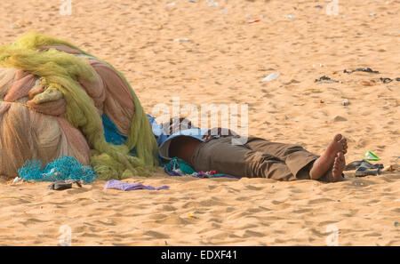 CHENNAI, INDE - 10 février : Un homme non identifié dort sur le sable à proximité de la Marina Beach le 10 février 2013 à Chennai, dans l'INDI Banque D'Images