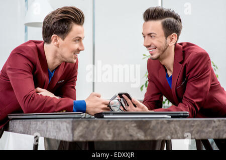 Deux frères jumeaux travaillant au bureau Banque D'Images