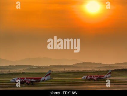 L'Asie de l'air avions avions avions roulant sur la voie de circulation en attente de décollage à l'Aéroport International de Kuala Lumpur au lever du soleil. Banque D'Images