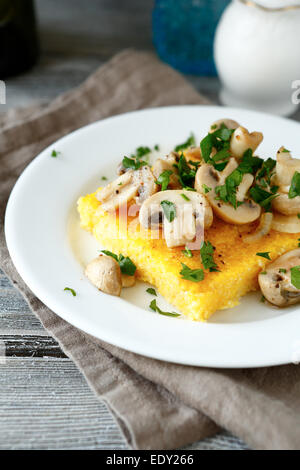 Polenta avec champignons savoureux dans une assiette blanche, de l'alimentation close up