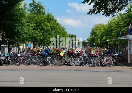 Bicyclettes et des paniers de fleurs sur un pont sur un canal, Utrechtsestraat, Amsterdam, Hollande du Nord, Pays-Bas, Europe Banque D'Images