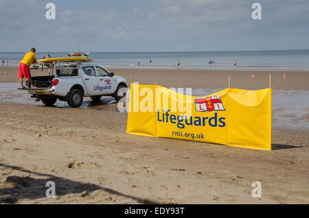 Jeune homme de devoir, en tant que sauveteur RNLI est à regarder les gens de mer et debout sur l'arrière du camion en stationnement - Whitby, North Yorkshire, Angleterre, Royaume-Uni. Banque D'Images