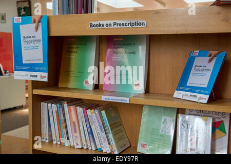 Panneau « Books on prescription » sur le plateau de la bibliothèque publique, rangée de livres d'auto-assistance, manuels et ressources CBT exposés - Baildon, West Yorkshire, Angleterre Banque D'Images