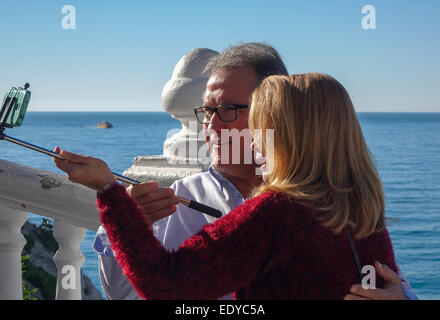 D'âge mûr en tenant à l'aide de bâton selfies selfy et téléphone cellulaire, téléphone portable photo sur journée ensoleillée au bord de la mer à Benidorm. Banque D'Images