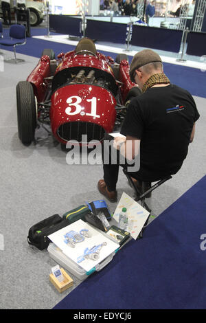 ​London, UK - 11 janvier 2015. Un artiste vu par un 1955 Lancia D50 Une formule un, l'un des cinq construits à partir de plans originaux de Anthony Maclean à l'inaugural Classic Car Show qui a eu lieu au London's un Excel Centre. Crédit : David Mbiyu/ Alamy Live News Banque D'Images