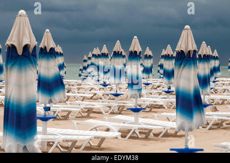 C'est l'arrière-plan sur la plage. Des parasols a été fermé, de gros nuages s'accrochaient à la mer. Banque D'Images