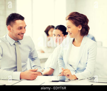 E monde colleagues talking in office Banque D'Images