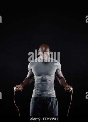 Portrait d'homme africain masculin la corde à sauter avec copie espace. Portrait of muscular young man exercising with la corde à sauter. Banque D'Images