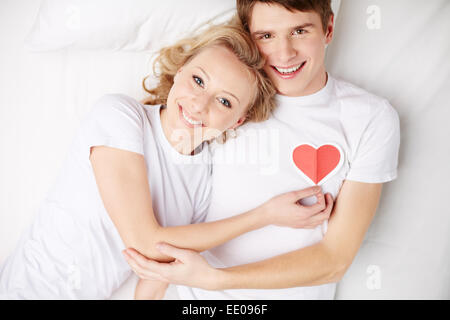Heureux couple Lying in Bed and looking at camera Banque D'Images