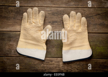 Paire de gants de travail allongés sur des planches de bois Banque D'Images