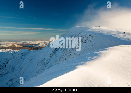 Les marcheurs sur sommet Helvellyn dans des conditions hivernales, Lake District, UK. Banque D'Images