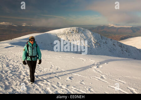 Une femelle walker sur sommet Helvellyn dans des conditions hivernales, Lake District, UK. Banque D'Images