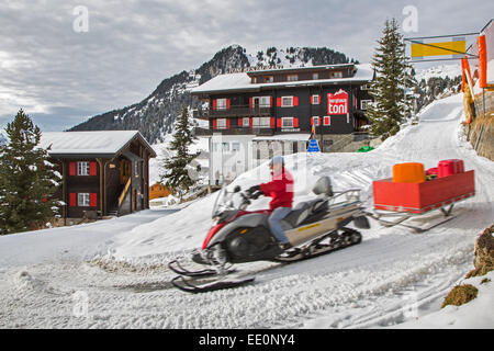 Sur l'homme portant une assurance motoneige de touristes à l'hôtel dans le village de Riederalp en hiver, Valais / Valais, Suisse Banque D'Images