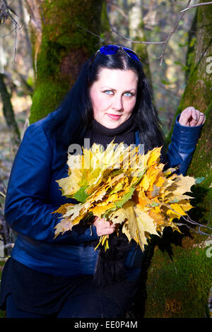 Fille de l'automne jouer à city park. Portrait de femme automne heureux belle et magnifique jeune femme dans la forêt en couleurs d'automne Banque D'Images