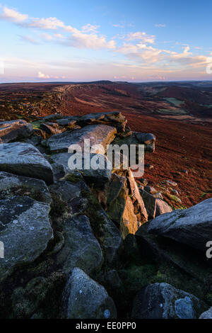 Un vent froid, le coucher du soleil sur le bord Stanage dans le Peak District, Derbyshire. Pierre Meulière Frosty dispose de dominer l'avant-plan. Banque D'Images