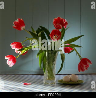 Tulipes rouges dans un vase de cristal avec des oeufs, comme still life Banque D'Images