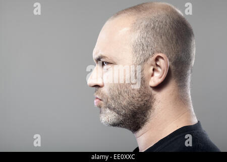 Portrait de l'homme sombre côté isolé sur fond gris avec copyspace Banque D'Images