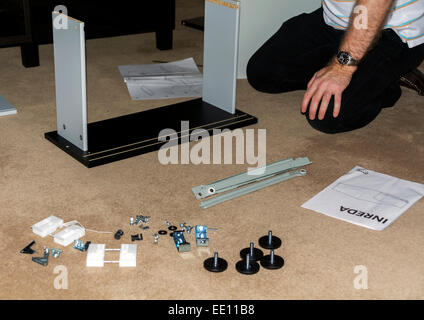 Cet homme est l'assemblage de meubles emballés à plat. Banque D'Images